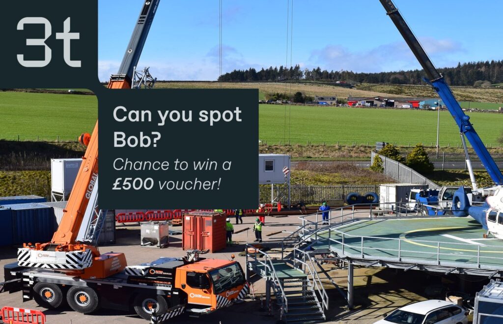 A construction site featuring cranes and workers wearing safety gear. Text reads "3t. Can you spot Bob? Chance to win a £500 training voucher!" in a large box at the top left. In the background, there are green fields and a partly cloudy sky. Don't miss this exciting competition!